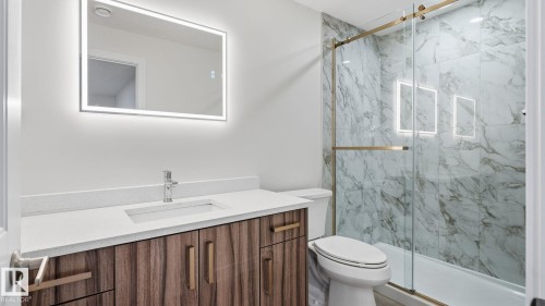 Modern bathroom featuring a wood-finish vanity with a white countertop and rectangular undermount sink - 4610 Westcliff Point(E) Sw, Edmonton, AB 