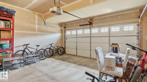 Attached garage with a sectional door, upper window panels, and a ceiling-mounted garage door opener - 4610 Westcliff Point(E) Sw, Edmonton, AB 