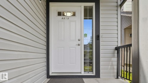 White paneled entry door with transom window, sidelight, and dark trim - 4610 Westcliff Point(E) Sw, Edmonton, AB 