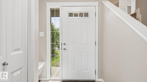 White paneled door with transom window, full-length sidelight, and wood-finish flooring - 4610 Westcliff Point(E) Sw, Edmonton, AB 