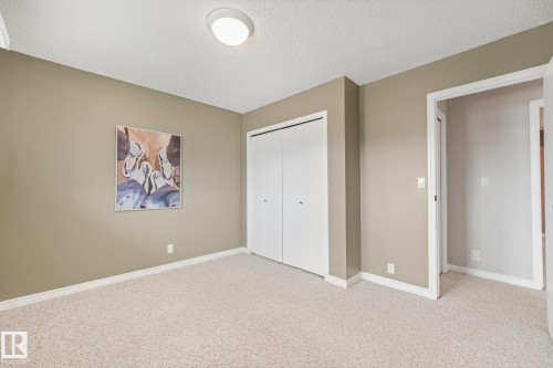 Neutral-toned room featuring light-colored carpeting and white baseboards - 5502 45 Street, Stony Plain, AB - Indoor