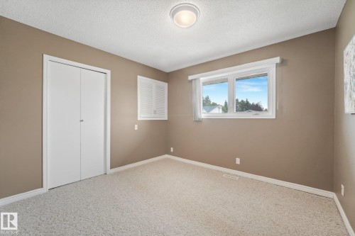 Bedroom featuring neutral paint, light-toned carpet, and a double-pane window - 5502 45 Street, Stony Plain, AB - Indoor Photo Showing Other Room