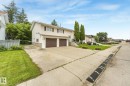 Split-level residence featuring white siding, brown garage doors, and a concrete driveway - 5502 45 Street, Stony Plain, AB  - Outdoor 