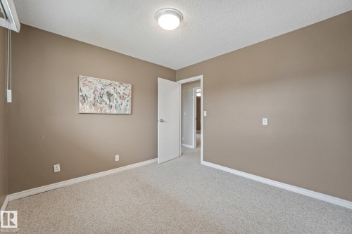 Carpeted room with neutral-toned walls, white trim, and a flush-mount ceiling light fixture - 5502 45 Street, Stony Plain, AB - Indoor Photo Showing Other Room