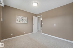 Carpeted room with neutral-toned walls, white trim, and a flush-mount ceiling light fixture - 