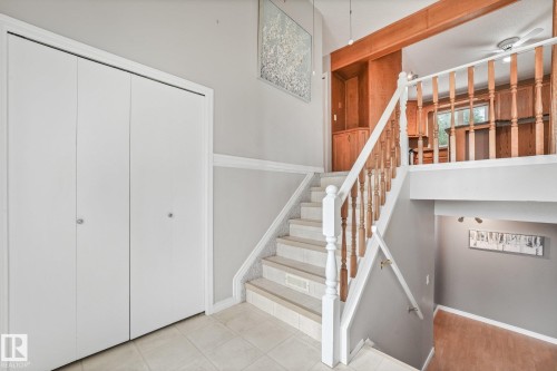 Two-tone staircase with wood-toned banister and white balusters - 5502 45 Street, Stony Plain, AB - Indoor Photo Showing Other Room