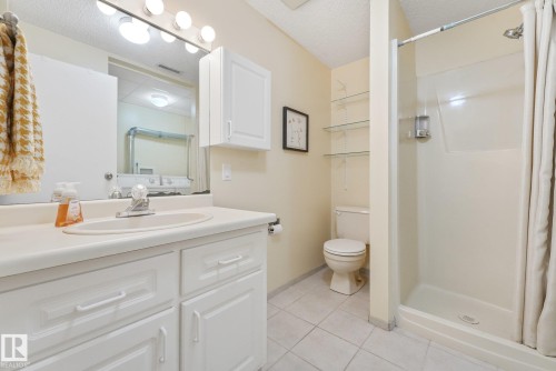 Bathroom featuring a single vanity with built-in cabinetry, an integrated sink, and a wall-mounted mirror with overhead lighting - 5502 45 Street, Stony Plain, AB - Indoor Photo Showing Bathroom