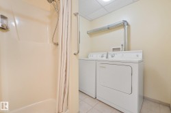 Dedicated laundry area featuring a white washer and dryer with overhead ventilation - 