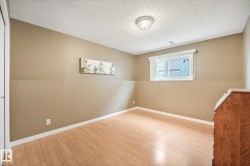 Room featuring neutral wall tones and wood-finish flooring - 