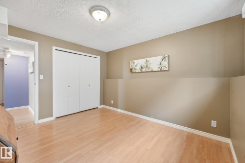 Room featuring wood-finish flooring, neutral-toned walls, white trim, and a flush mount ceiling light - 5502 45 Street, Stony Plain, AB - Indoor Photo Showing Other Room