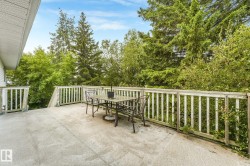 Expansive outdoor deck with a textured surface and white wood railing - 