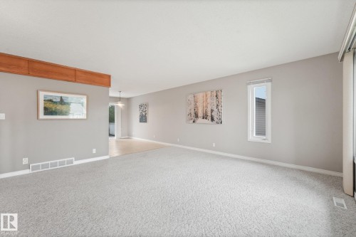 Spacious interior with neutral gray walls, light gray carpet, and white trim - 5502 45 Street, Stony Plain, AB - Indoor Photo Showing Other Room