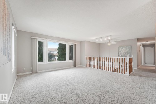 Expansive room with neutral carpet flooring and light gray painted walls - 5502 45 Street, Stony Plain, AB - Indoor Photo Showing Other Room