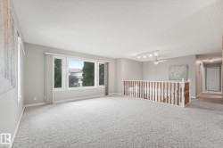 Expansive room with neutral carpet flooring and light gray painted walls - 