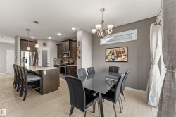 Wood-finish flooring, recessed lighting, and a kitchen island with pendant lighting - 