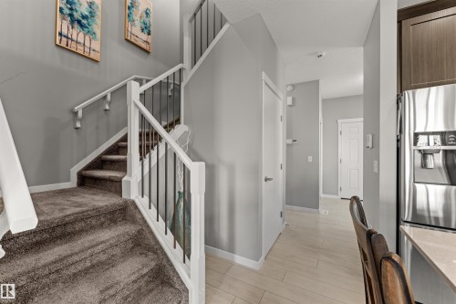 Staircase featuring white newel posts and handrails with black metal spindles - 12218 176 Avenue Nw, Edmonton, AB 