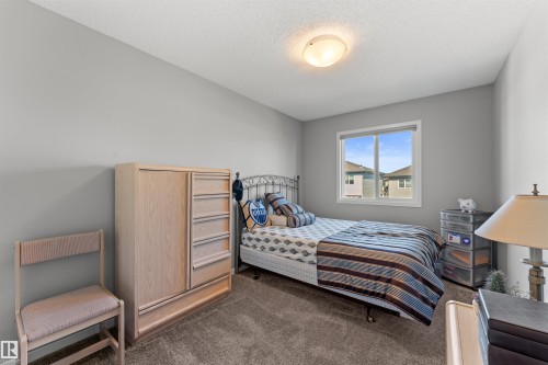 Carpeted bedroom with a single window and an overhead flush mount light fixture - 12218 176 Avenue Nw, Edmonton, AB 