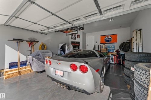 Spacious garage with painted walls, overhead lighting, and a durable concrete floor - 12218 176 Avenue Nw, Edmonton, AB 
