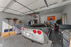 Spacious garage with painted walls, overhead lighting, and a durable concrete floor - 