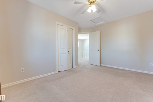 Neutral wall paint, carpet flooring, a ceiling fan with integrated lighting, and a closet with bifold doors - 1124 37A Avenue Nw, Edmonton, AB 