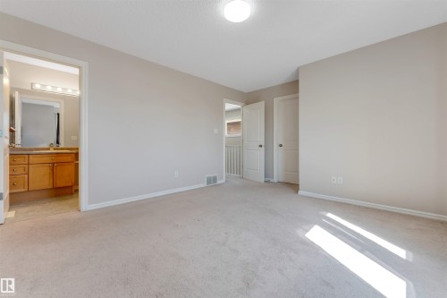 Carpeted flooring, neutral wall tones, recessed ceiling light, wood-finish vanity with countertop, and vanity lighting - 1124 37A Avenue Nw, Edmonton, AB 