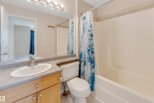 Vanity with wood-finish cabinetry, solid surface countertop, and integral sink - 1124 37A Avenue Nw, Edmonton, AB 
