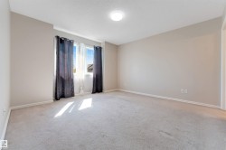 Carpeted room with double windows, neutral wall tones, and a flush-mount ceiling light - 