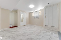 Spacious room featuring light-toned walls, a flush-mount ceiling light, and light-toned, patterned floor tiles - 