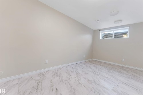 Light-colored walls, contemporary flooring, white trim, recessed lighting, and a window with blinds - 1124 37A Avenue Nw, Edmonton, AB 