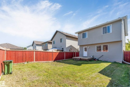 Expansive backyard featuring a wood privacy fence, a multi-level wood deck, and a vinyl-sided exterior - 1124 37A Avenue Nw, Edmonton, AB 