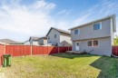 Expansive backyard featuring a wood privacy fence, a multi-level wood deck, and a vinyl-sided exterior - 1124 37A Avenue Nw, Edmonton, AB 
