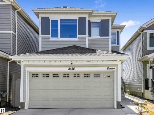 Two-story exterior with horizontal siding, an attached garage, white trim, and a dark shingle roof - 2435 12 Avenue Nw, Edmonton, AB 