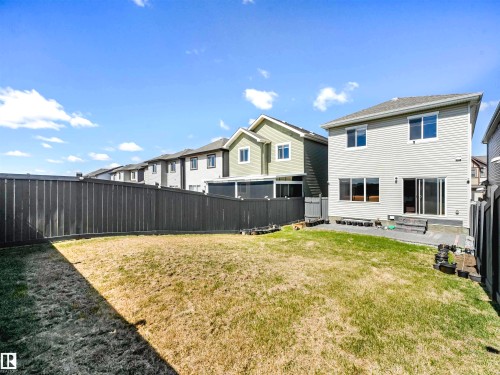 Expansive backyard featuring a manicured lawn, a privacy fence, and a concrete patio - 2435 12 Avenue Nw, Edmonton, AB 