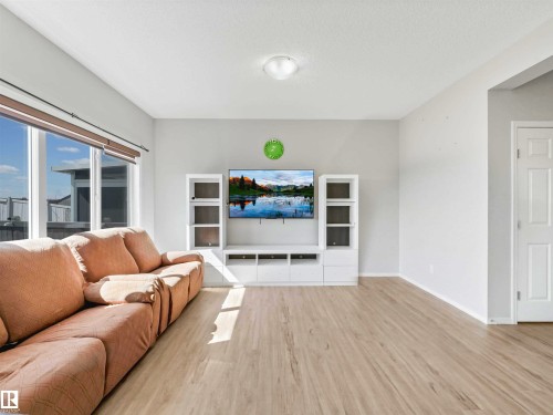Wood-finish flooring, white walls, large windows with roller shades, and a white ceiling-mounted light fixture - 2435 12 Avenue Nw, Edmonton, AB 
