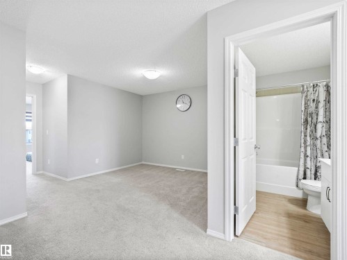 Neutral-toned room with carpeted flooring, featuring a flush-mount ceiling light - 2435 12 Avenue Nw, Edmonton, AB 