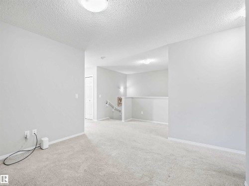 Light-colored carpeting throughout, white painted walls, and a ceiling-mounted light fixture - 2435 12 Avenue Nw, Edmonton, AB 