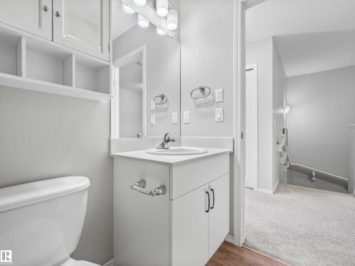 White vanity with integrated sink, chrome faucet, and storage cabinetry - 2435 12 Avenue Nw, Edmonton, AB 