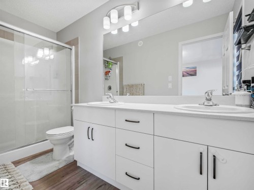 Dual vanity with undermount sinks, white cabinetry, and brushed nickel hardware - 2435 12 Avenue Nw, Edmonton, AB 