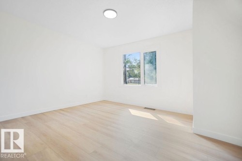 Recessed ceiling light, white walls, wood-finish flooring, white trim, and a rectangular window - 12303 131 St Nw Nw, Edmonton, AB 
