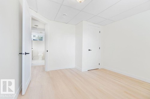 Light wood-finish flooring, white walls, and a drop ceiling with recessed lighting - 12303 131 St Nw Nw, Edmonton, AB 