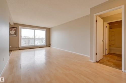 Living room with entry to the second living area with a private bathroom, bedroom and storage area. - #402 11019 107 St Nw, Edmonton, AB 