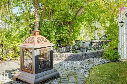 A beautiful backyard features a small pond with a waterfall - 14243 24 Street Nw, Edmonton, AB 