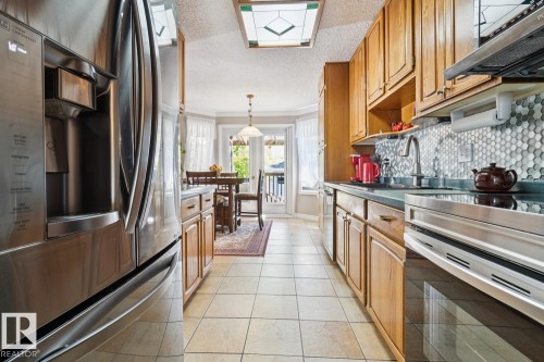 With a stylish back splash and upgraded stainless steel appliances - 14243 24 Street Nw, Edmonton, AB 