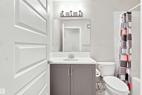 Bathroom vanity with an integrated sink, polished chrome faucet, and a quartz-finish countertop - 8024 Orchards Green Green Sw, Edmonton, AB 