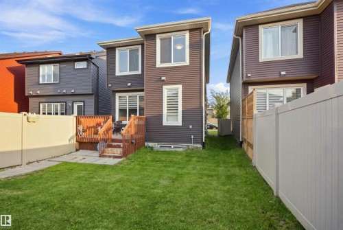 Expansive green lawn with a wooden deck and privacy fencing - 8024 Orchards Green Green Sw, Edmonton, AB 