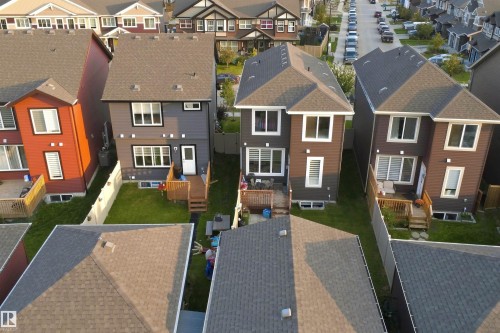 Rear exterior with a wood deck, fenced yard, and multiple windows - 8024 Orchards Green Green Sw, Edmonton, AB 