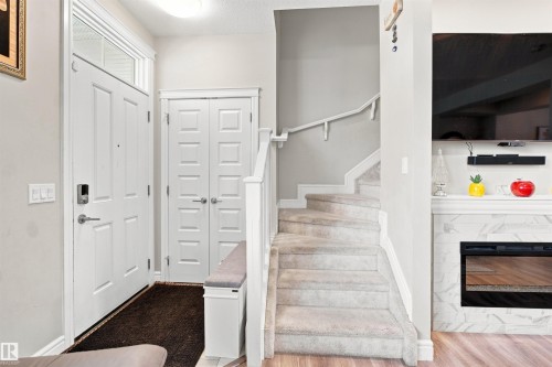 Entryway with white paneled door and transom window - 8024 Orchards Green Green Sw, Edmonton, AB 