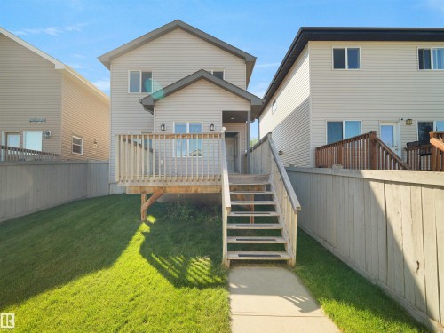 Raised wood deck with railings, exterior siding, and a concrete pathway leading to steps - 5190 1B Avenue Sw, Edmonton, AB 