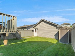 Expansive grassy yard with a multi-level wood deck and stairs - 