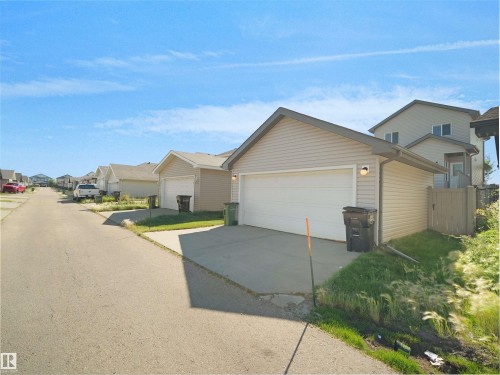 Detached two-story residence with a single-car garage, light-toned siding, and a fenced yard section - 5190 1B Avenue Sw, Edmonton, AB 